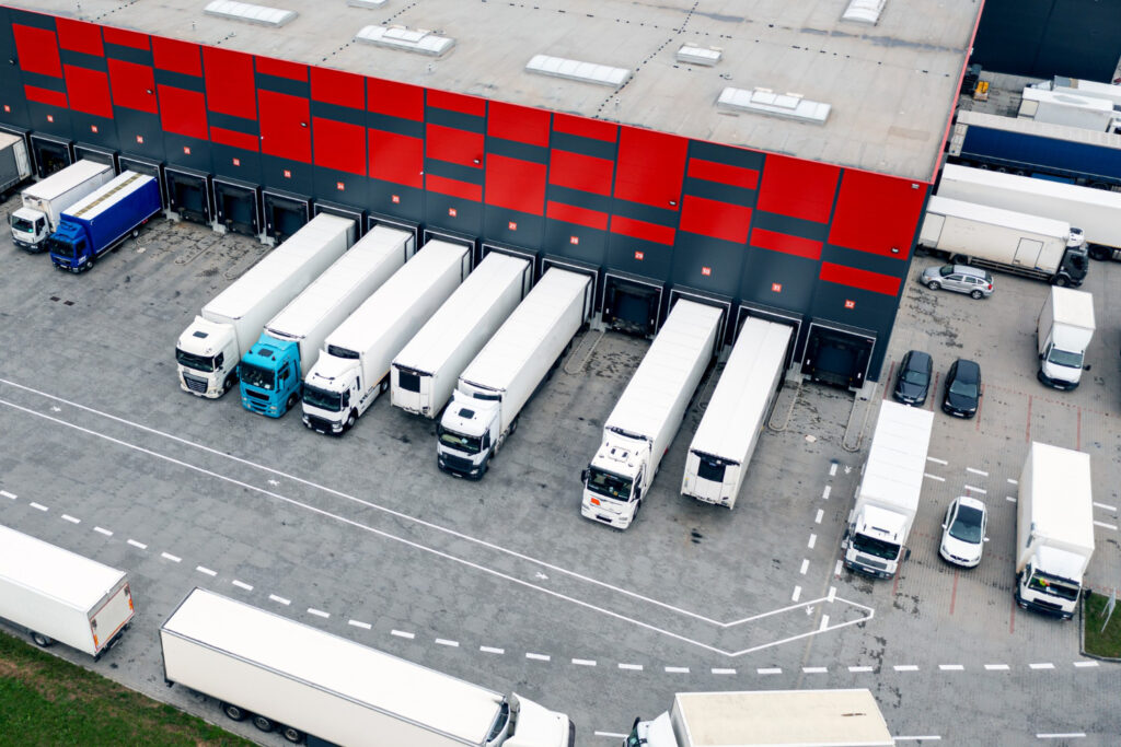 Cross-docking warehouse with trucks loading and unloading shipments in real time.