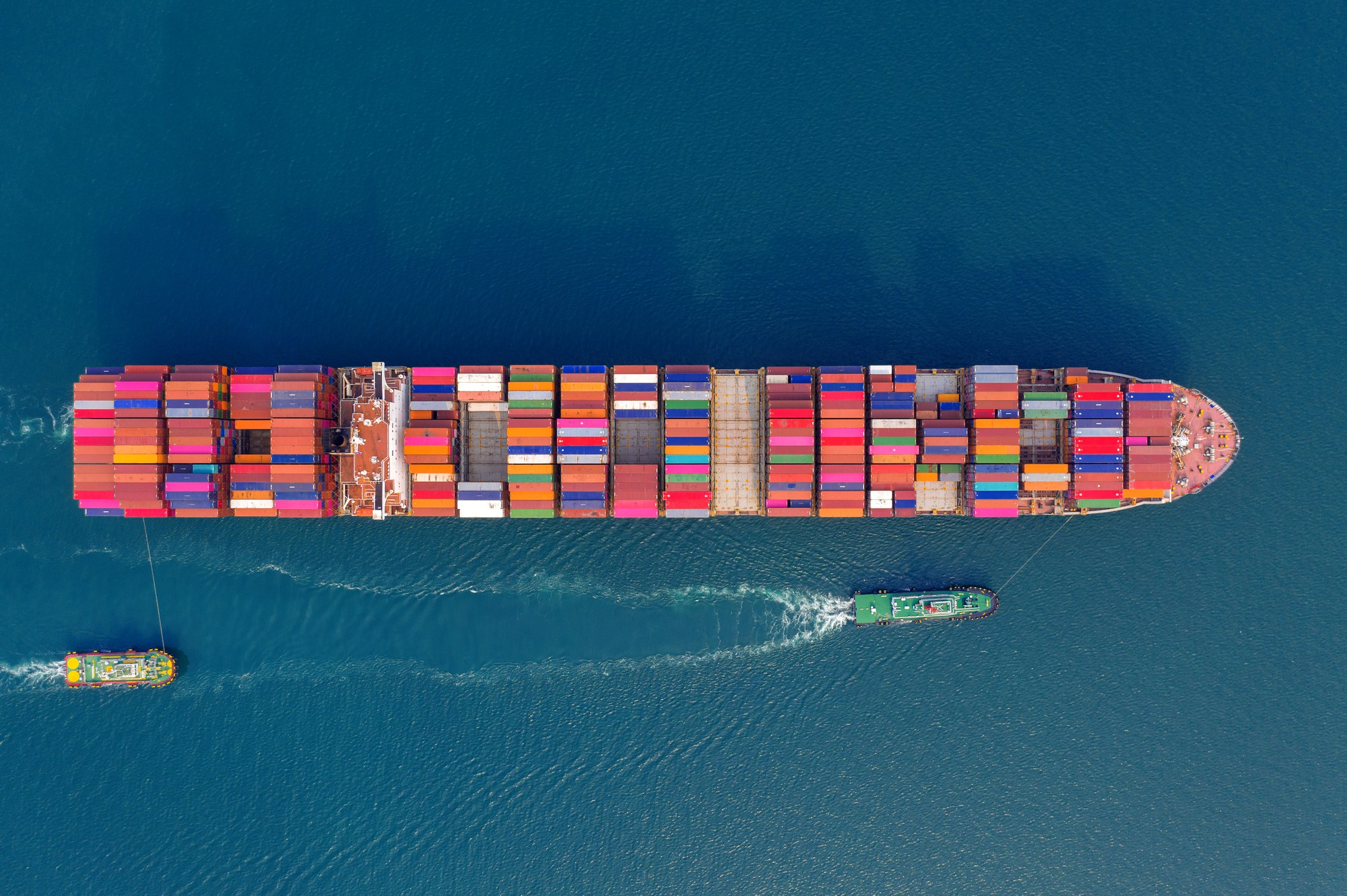 Container ship at sea with cargo stacked, symbolizing global logistics challenges in 2025