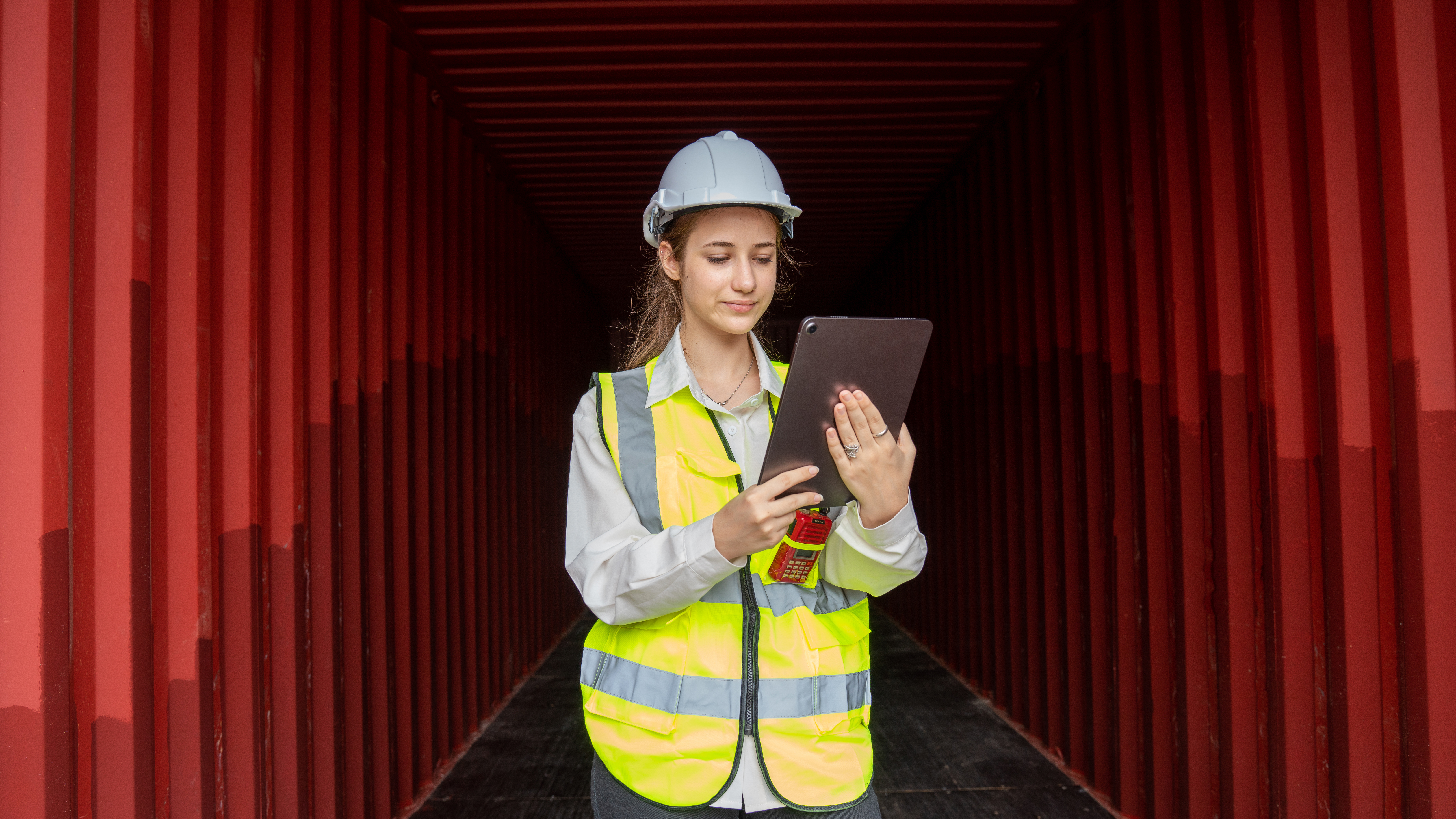 logistics manager monitoring container drayage operations at port terminal to reduce landed cost