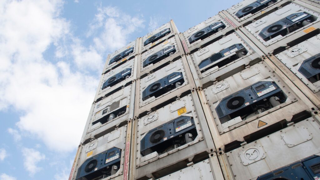 Reefer containers with cooling units stacked at a port, showing Houston temperature-controlled imports